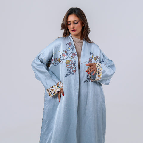 عباية فاخرة إصدار محدود مزيج من اللينن والحرير الطبيعي الخالص، وتزينت بتطريز يدوي بخيوط الريسم المستوحى من الزخارف النباتية، لتمنحك إطلالة تنبض بالرقي والفخامة الهادئة