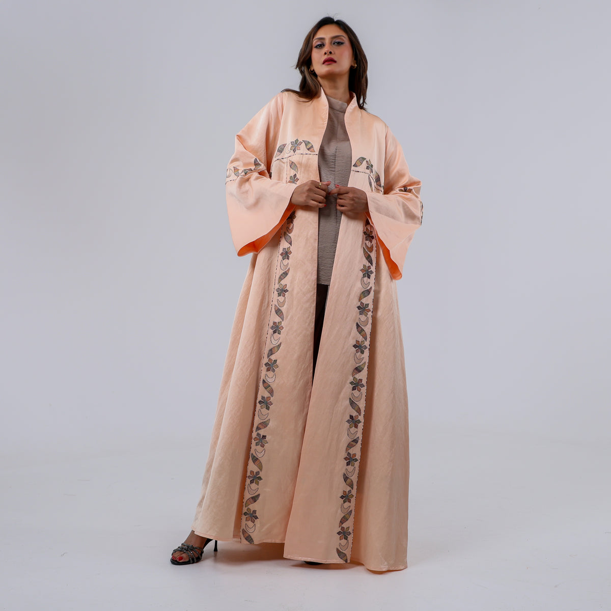 عباية فاخرة إصدار محدود، صُممت من قماش تهاني بوتيك الحصري الممزوج باللينن والحرير الطبيعي الخالص، وتزينها تطريزات يدوية محبوكة بخيوط الريسم بتفاصيل نباتية أنيقة تمنحها لمسة فنية راقية وحضورًا يفيض بالفخامة
