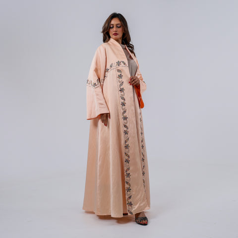 عباية فاخرة إصدار محدود، صُممت من قماش تهاني بوتيك الحصري الممزوج باللينن والحرير الطبيعي الخالص، وتزينها تطريزات يدوية محبوكة بخيوط الريسم بتفاصيل نباتية أنيقة تمنحها لمسة فنية راقية وحضورًا يفيض بالفخامة