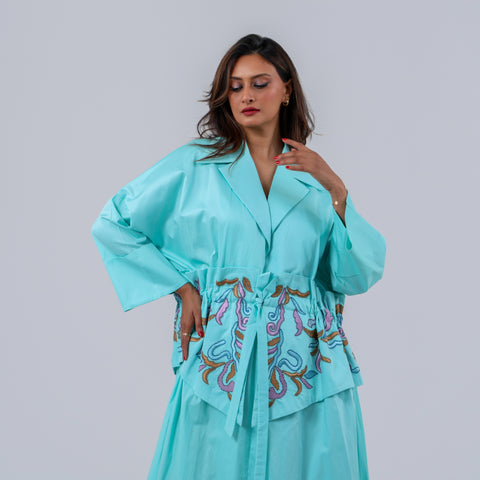 دراعة فاخرة من القطن الإيطالي الفاخر مزودة بحزام للتحكم في تضييق وتوسيع الخصر، تزينها تفاصيل تطريز يدوي متقن بخيوط الريسم، لتمنحك إطلالة راقية تجمع بين الراحة، والانسيابية، وفخامة الحرفة اليدوية الأصيلة