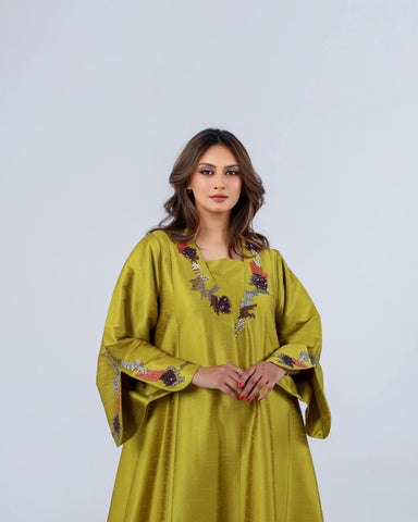 دراعة فاخرة من أجود أنواع قماش الشانتون، تزينها تفاصيل الشك اليدوي بخيوط الريسم والترتر الياباني، لتجمع بين انسيابية التصميم، وفخامة الخامة، والحرفية التي تميز إبداعات تهاني بوتيك